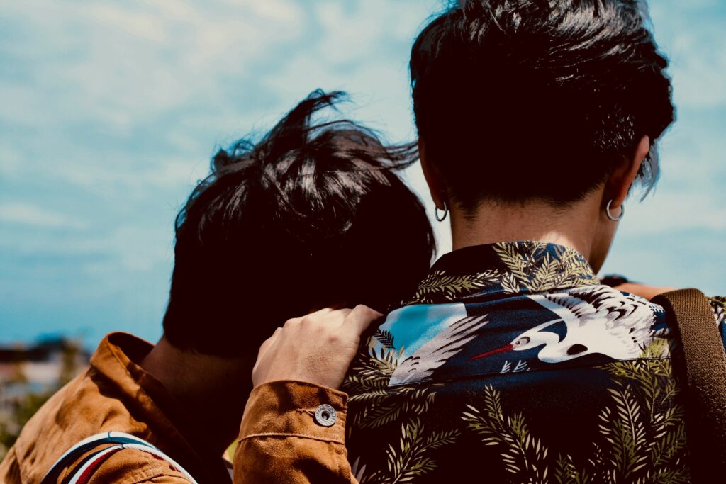 back of two men, one has head on the other's shoulder honey fangs 33iKv A1E2s unsplash