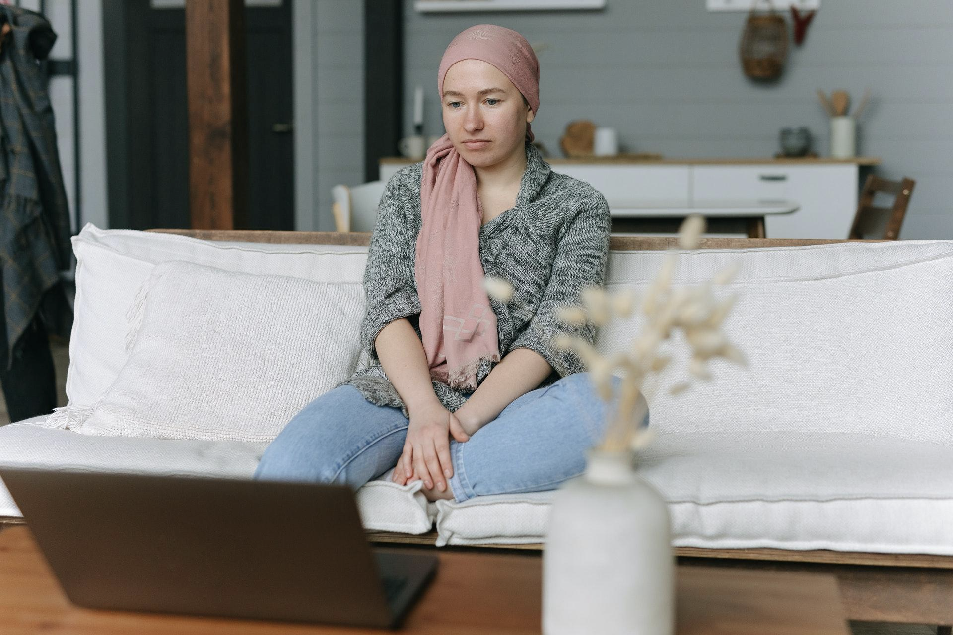 Woman in Pink Scarf on white couch Healing through your grief guest blog March 16 2022