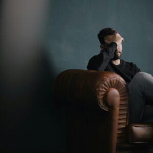 sad man on the couch nik shuliahin BuNWp1bL0nc unsplash