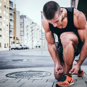 man tieing his shoes on street corner alexander redl d3bYmnZ0ank unsplash copy