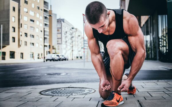 man tieing his shoes on street corner alexander redl d3bYmnZ0ank unsplash copy