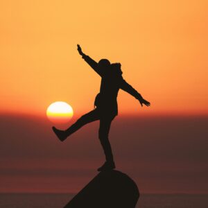 man balancing on a rock in sunset aziz acharki U3C79SeHa7k unsplash