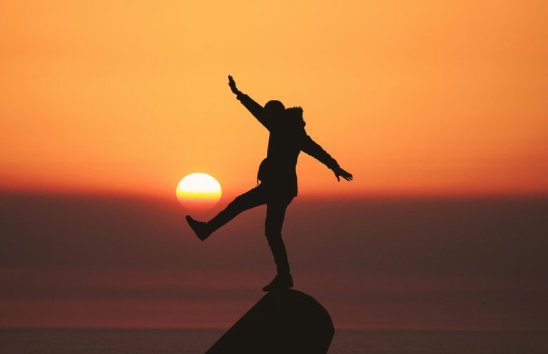 man balancing on a rock in sunset aziz acharki U3C79SeHa7k unsplash